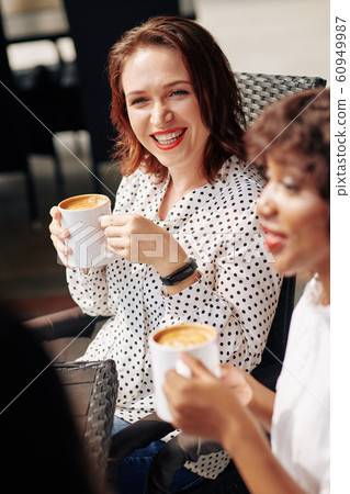 Laughing woman listening to story of friend 60949987