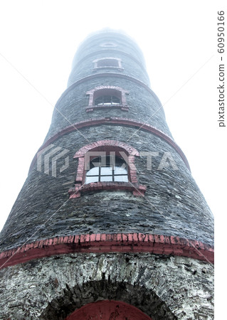 A lookout tower in the clouds. The stone tower is A lookout tower in the clouds. The stone tower is 60950166
