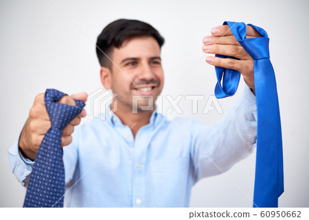 Smiling man choosing necktie Smiling man choosing necktie 60950662