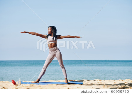Young woman in warrior pose Young woman in warrior pose 60950750