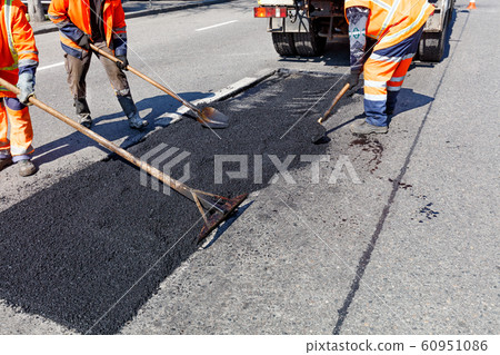 The workers' brigade clears a part of the asphalt 60951086