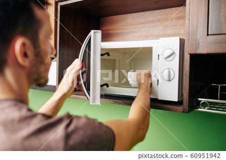 Man heating bowl of soup Man heating bowl of soup 60951942