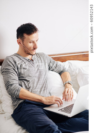 Man programming in bed 60952143