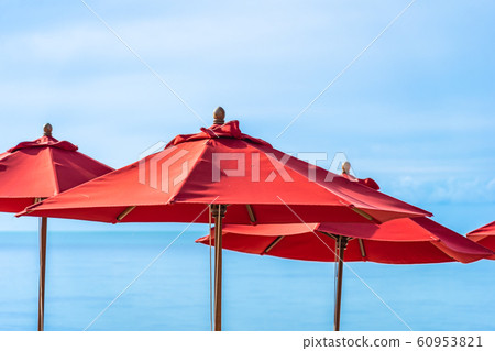 Beautiful outdoor tropical beach sea ocean with umbrella chair and lounge deck around there on white cloud blue sky 60953821