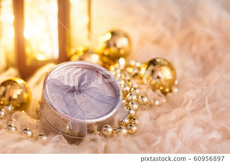 New Year's toys on white fur. Lantern, gold beads, gift box and disco balls. Christmas composition. 60956897