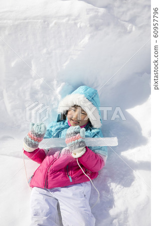 A child lying on the icicle playing in the snow A child lying on the icicle playing in the snow 60957796