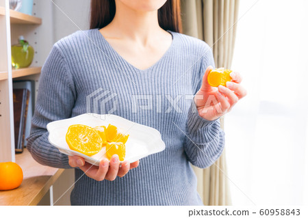 Woman cutting and eating oranges Woman cutting and eating oranges 60958843