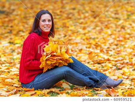 Young pretty woman walking in an autumn fall park Young pretty woman walking in an autumn fall park 60959521