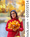 Young pretty woman walking in an autumn fall park 60959554