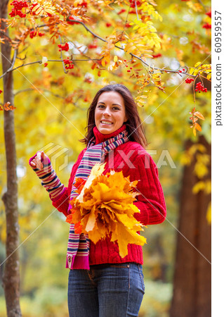 Young pretty woman walking in an autumn fall park Young pretty woman walking in an autumn fall park 60959557