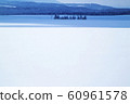 A snow-covered endless snowy field on Furano Hill in Hokkaido, where the sunlight is blocked by clouds and the sun is shady and dark 60961578