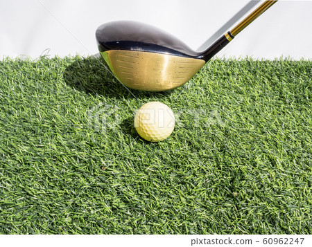 Driving the golf ball with the driver on artificial grass and white background Driving the golf ball with the driver on artificial grass and white background 60962247