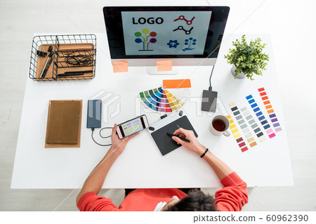 Web designer with stylus and graphics tablet choosing printing type for logo 60962390