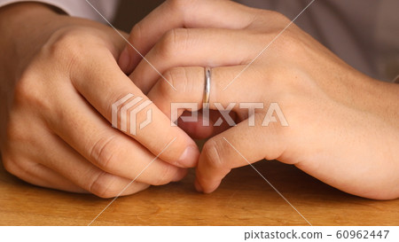 Woman removing a ring Woman removing a ring 60962447