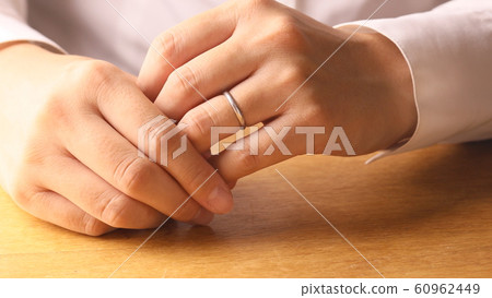 Woman removing a ring Woman removing a ring 60962449