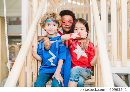 Three affectionate little friends in costumes playing on staircase together 60963241