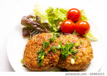 Chicken hamburger with mini tomato and sunny lettuce. Sauce and green onions. 60964223