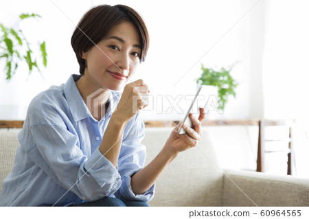 Woman Smartphone Sofa Living Room Lifestyle Relax Smile 60964565