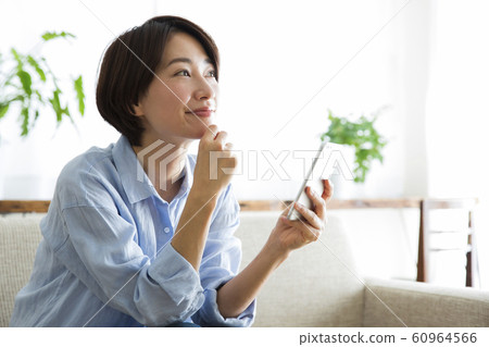 Woman Smartphone Sofa Living Room Lifestyle Relax Smile 60964566