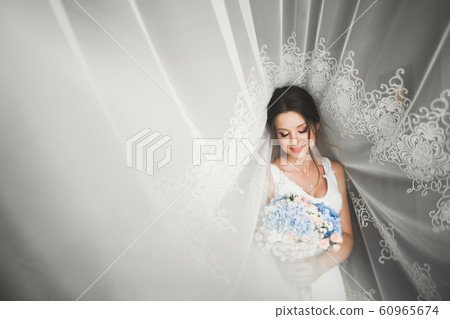 Portrait of beautiful bride with fashion veil at wedding morning 60965674