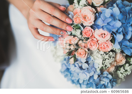 Bride holding big and beautiful wedding bouquet with flowers 60965686