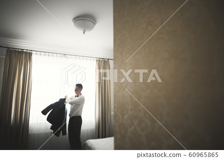 Young handsome man relaxing at his apartment in a hotel after business meeting Young handsome man relaxing at his apartment in a hotel after business meeting 60965865