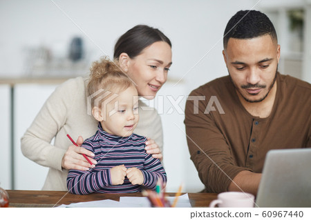 Mixed-Race Family Using Laptop at Home 60967440