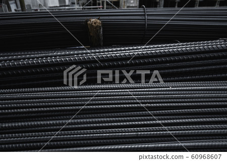 Building armature in the warehouse of metallurgical products or on construction site. Stack of heavy metal reinforcement bars with periodic profile texture. Steel construction armature. 60968607