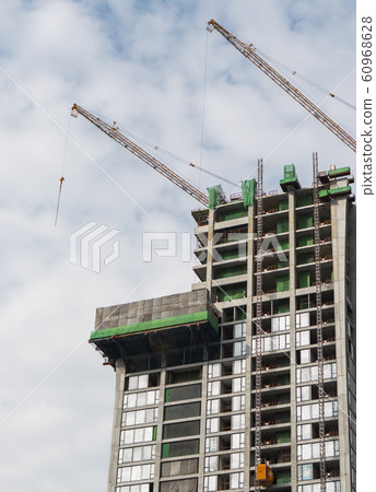 Construction site of building a high-rise building with a cranes against blue sky. 60968628