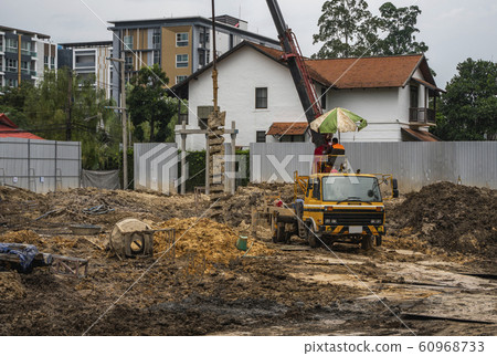 Drilling rigs for the construction of building foundations. Construction work. Drilling pile foundations under the ground. Boring holes in ground with drilling rig during building construction. Drilling rigs for the construction of building foundations. Construction work. Drilling pile foundations under the ground. Boring holes in ground with drilling rig during building construction. 60968733