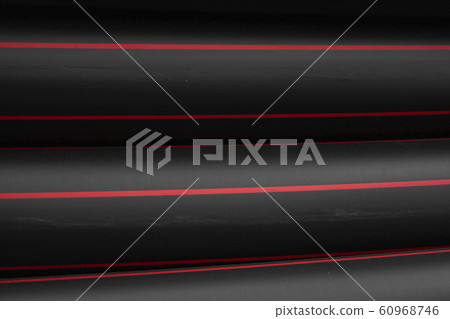 Black rubber or plastic pipes with a red lines as a construction material and equipment at building site. Using as a water pipe. Black rubber or plastic pipes with a red lines as a construction material and equipment at building site. Using as a water pipe. 60968746