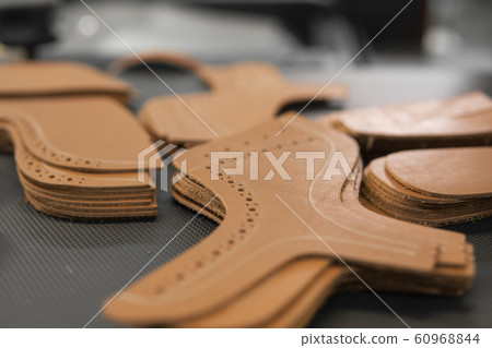 Different forms of leather pieces which will be use for making a shoes on a shoes factory. Prepared, bundled leather parts, used in the production of shoes. Different forms of leather pieces which will be use for making a shoes on a shoes factory. Prepared, bundled leather parts, used in the production of shoes. 60968844