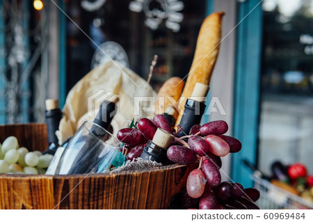 basket with bottles of wine grapes and bread 60969484
