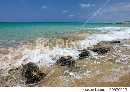 Small sea waves crushing on black rocks at sandy Small sea waves crushing on black rocks at sandy 60970625