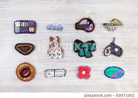 various handcrafted embroidered brooches on gray 60971001