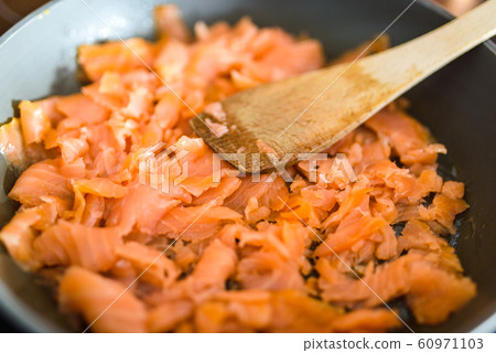 Pan with Pile of Cut Salmon Pieces, on stove. with wooden spoon Pan with Pile of Cut Salmon Pieces, on stove. with wooden spoon 60971103