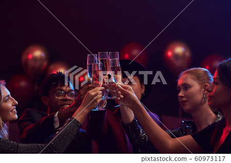 Friends Raising Champagne Glasses in Nightclub 60973117