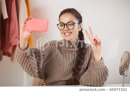 Young Woman Taking Selfie at Home 60973302