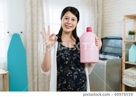 pregnant woman is holding fabric softener 60978559