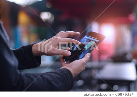 Man using mobile smartphone for online banking in with stethoscope in hand and Patients come to the hospital background. 60979354