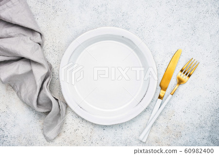 Empty plate and golden cutlery Empty plate and golden cutlery 60982400