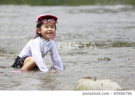 Infant (4 years old) playing in the river 60986786