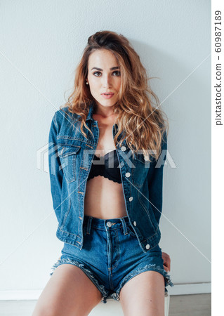 portrait of a beautiful fashionable woman in a denim jacket and shorts 60987189