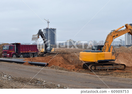 Excavator load the sand to the heavy dump truck Excavator load the sand to the heavy dump truck 60989753