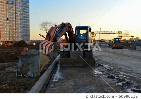 Tracked excavator working at a construction site Tracked excavator working at a construction site 60990119