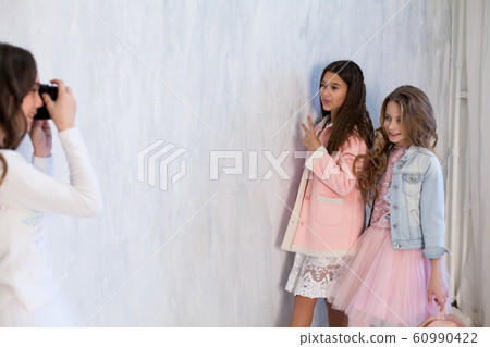 Portrait of three beautiful fashionable girls in dresses with a camera in winter Portrait of three beautiful fashionable girls in dresses with a camera in winter 60990422