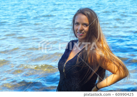 woman smiling on vacation blue water background  60990425