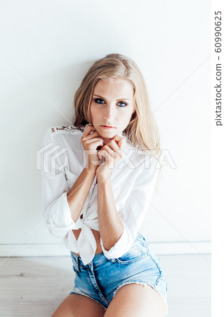 beautiful blonde girl with blue eyes sitting on the floor in a white room 1 beautiful blonde girl with blue eyes sitting on the floor in a white room 1 60990625