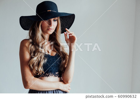 blonde girl with blue eyes a hat with a brim on a white background 60990632