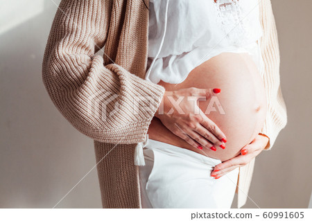 the stomach of a pregnant woman hands closeup the stomach of a pregnant woman hands closeup 60991605